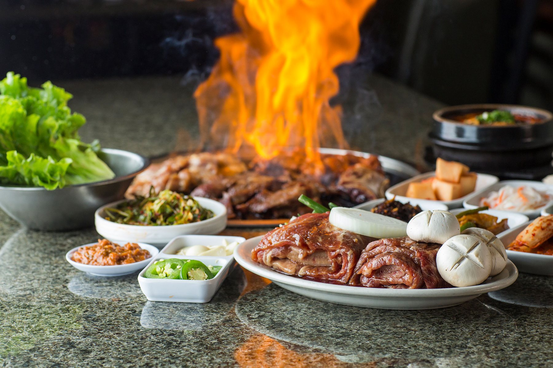 Korean BBQ grilled at the table with side dishes